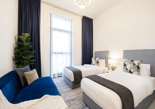 a hotel room with two beds and a blue couch at Lux Escape, Burj Crown Opera View, Near Dubai Mall in Dubai