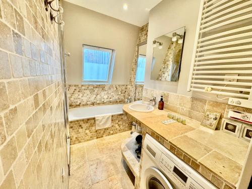 une salle de bain avec une douche, un lavabo et une baignoire dans l'établissement 27 avenue de la bourdonnais 75007 CHABLIS, à Paris