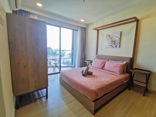 a bedroom with a bed and a large window at Timurbay Seafront Residences by Nature Home in Kuantan