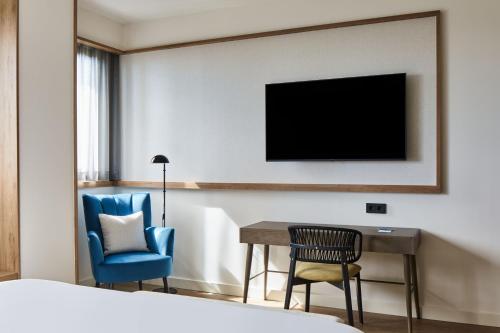 a hotel room with a bed and a desk and a television at Four Points by Sheraton Barcelona Airport in Barcelona