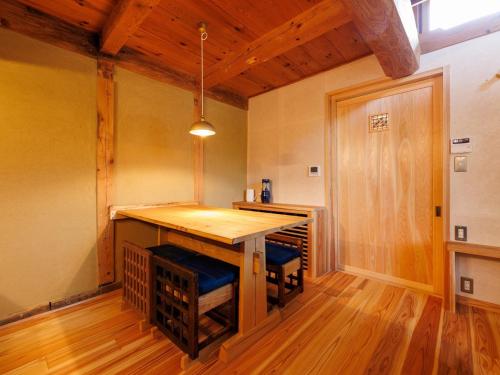 a kitchen with a wooden table in a room at 隠れ家stay蔵ひなわら in Ohnan-cho