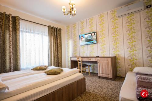 a bedroom with two beds and a desk in it at Pensiunea Royal Spa in Piatra Neamţ
