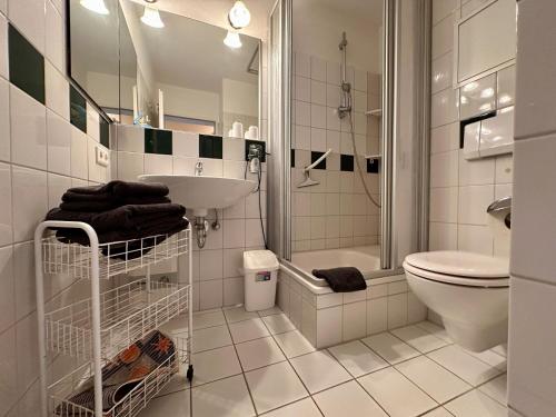 a white bathroom with a sink and a toilet at Ferienwohnung De Diek 105 in Dorum
