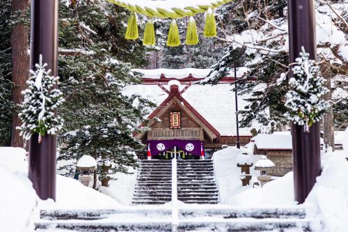 a temple in a snow covered yard at A-JA in Niki