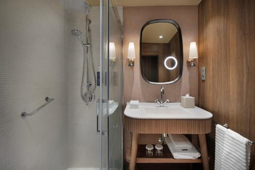 a bathroom with a sink and a shower with a mirror at The Westin Madrid Cuzco in Madrid