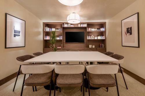 a dining room with a large white table and chairs at The Westin Madrid Cuzco in Madrid