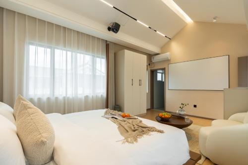 a room with a white bed and a screen at Dali Yufu B&B Hotel in Dali Shuanglang