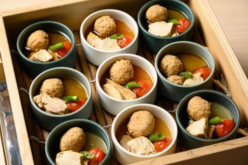 a wooden box filled with small dishes of food at Hotel Torifito Kashiwanoha in Kashiwa