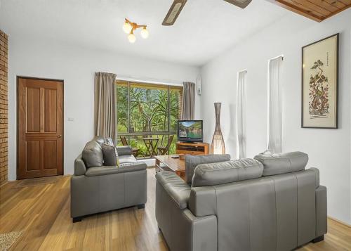 a living room with two couches and a television at Banksia in Sawtell