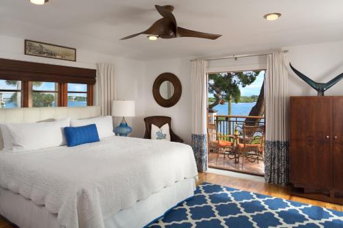 a bedroom with a bed and a balcony at Black Dolphin Inn in New Smyrna Beach