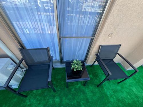 two chairs and a table in a room with green grass at Ikebukuro Area R2 NishiikeApartment 5F No Elevator in Tokyo