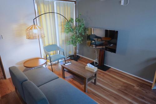 a living room with a couch and a table at Hook House Stay Kanazawa in Kanazawa