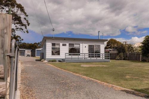 Ein weißes Haus an der Seite einer Straße in der Unterkunft Bay Hideaway Stieglitz in Saint Helens Island