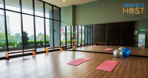 a yoga room with pink mats on a wooden floor at Neu Suites @ 3rdNvenue by Perfect Host in Kuala Lumpur