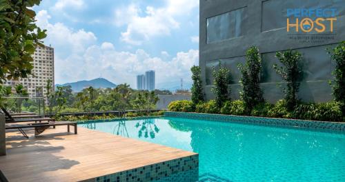 a swimming pool with a bench next to a building at Neu Suites @ 3rdNvenue by Perfect Host in Kuala Lumpur
