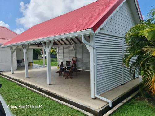 a roof over a deck with a red roof at Maison accueillante à Anse-Bertrand avec jardin privé 70 m² in Anse-Bertrand
