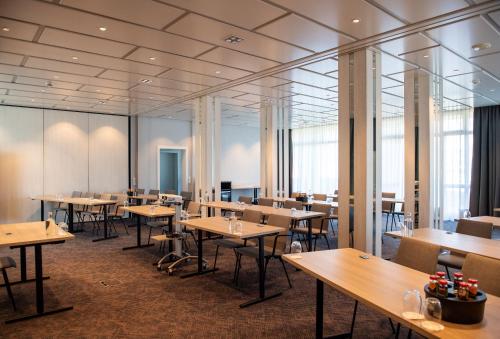 a dining room with tables and chairs and windows at Best Western Plus Hotel Fellbach-Stuttgart in Fellbach