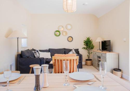a living room with a table and a couch at The Barn in Longhope - Luxury Barn Conversion in Longhope