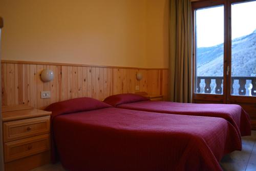 カステリャ・デ・ヌクにあるHostal La Neuのベッドルーム1室(ベッド2台、大きな窓付)