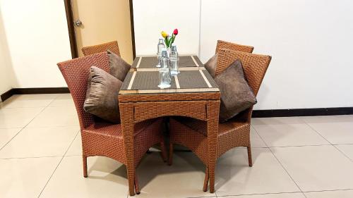 a table with chairs and a vase of flowers on it at Bayou Lagoon Park Resort in Melaka