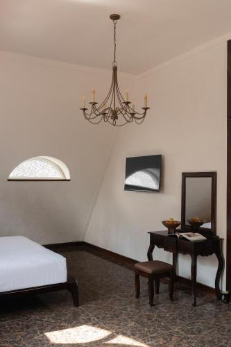 a bedroom with a bed and a mirror and a table at The Manor Villas Da Lat in Xuan An
