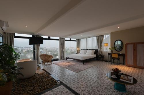 a hotel room with a bed and a large window at The Manor Villas Da Lat in Xuan An