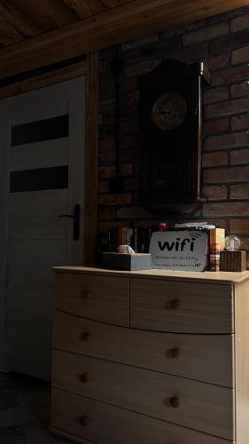 a dresser with a clock on top of it at Apartamenty 3 Pory Roku in Komarno
