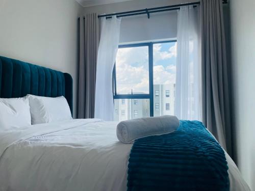 - un lit avec une serviette devant une fenêtre dans l'établissement Mikeys place On New: 2bed2bath no.1 with Free WiFiNetflix, à Midrand
