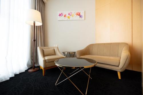 a room with a chair and a table and a lamp at Paya Bunga Hotel Terengganu in Kuala Terengganu