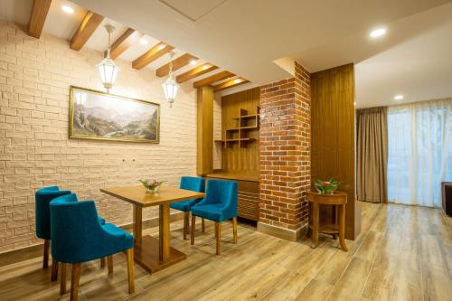 a dining room with a table and blue chairs at Dreamland Gold Resort & Hotel in Bhairāhawā