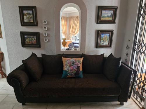 a brown couch in a living room with a mirror at Epicure Home Guesthouse in Heidelberg