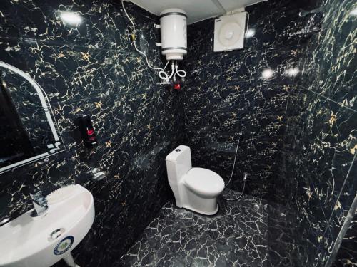 a bathroom with a white toilet and a sink at Shree Balaji Comfort in Varanasi