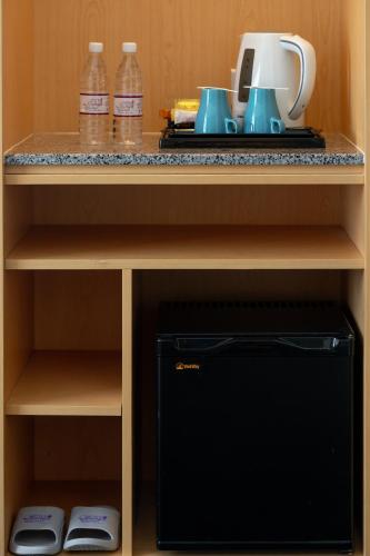 a kitchen shelf with a counter top with a coffee maker at Paya Bunga Hotel Terengganu in Kuala Terengganu