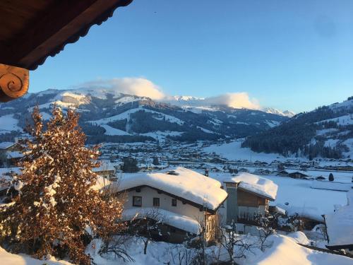 a snow covered village with a christmas tree and mountains at Villa Kitzbühel in Kirchberg in Tirol