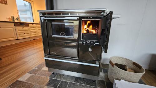 a kitchen with an oven with a fire in it at Christians Alpenparadies in Bad Mitterndorf