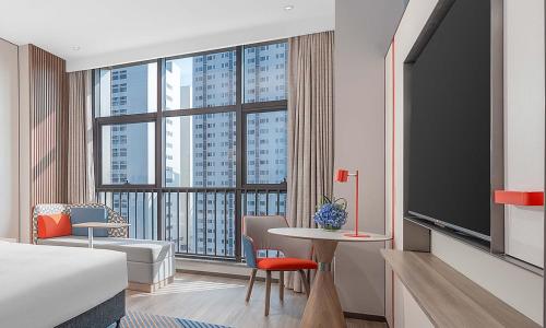 a hotel room with a bed and a large window at Holiday Inn Express Foshan Shunde Lecong by IHG in Shunde