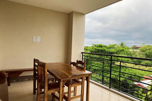 a wooden table and chairs on a balcony with a view at Sta Rosa Inn Iloilo powered by Cocotel in Iloilo City