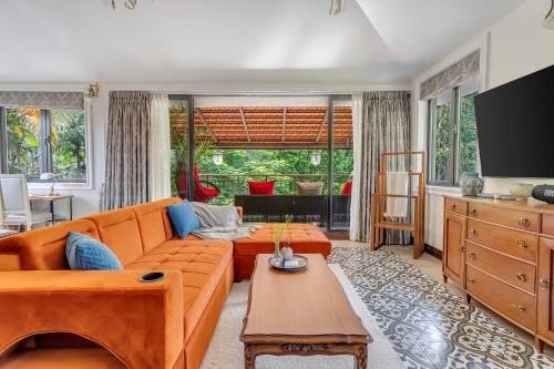 a living room with a couch and a table at Villa Stairway to Heaven by tisyastays in Candolim