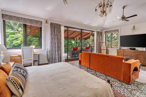 a bedroom with a large bed and a television at Villa Stairway to Heaven by tisyastays in Candolim