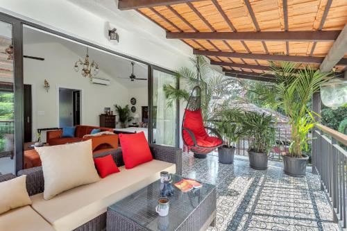 a living room with a couch and a table at Villa Stairway to Heaven by tisyastays in Candolim