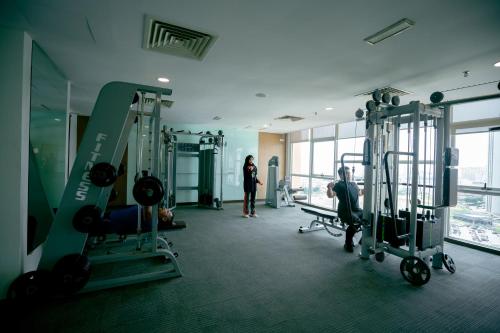 a gym with two people working out in the gym at Paya Bunga Hotel Terengganu in Kuala Terengganu