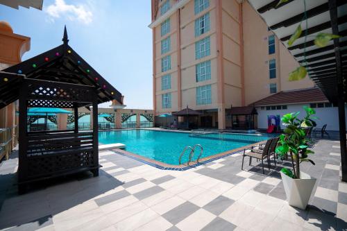 a swimming pool with a gazebo next to a building at Paya Bunga Hotel Terengganu in Kuala Terengganu