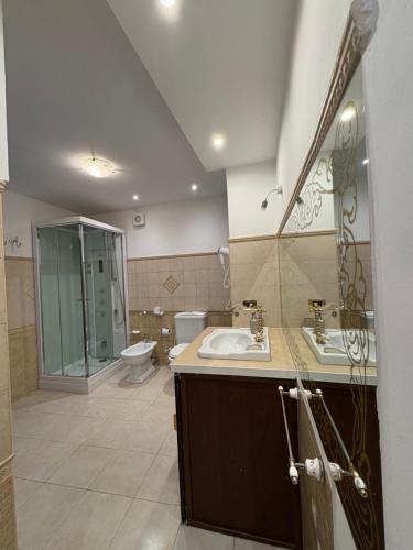 Un baño con dos lavabos, un inodoro y una ducha. en Wanderlust maison de voyage, en Catania