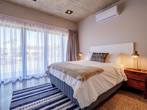 a bedroom with a bed and a large window at The Lofts on Manaar in Durban
