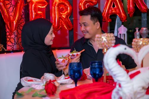 a man and a woman sitting at a table eating food at Paya Bunga Hotel Terengganu in Kuala Terengganu