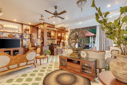a living room filled with furniture and a tv at Villa Stairway to Heaven by tisyastays in Candolim