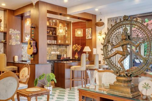 a bar with a statue in the middle of a room at Villa Stairway to Heaven by tisyastays in Candolim