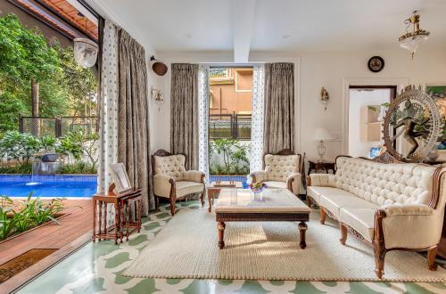 a living room with a couch and a table at Villa Stairway to Heaven by tisyastays in Candolim