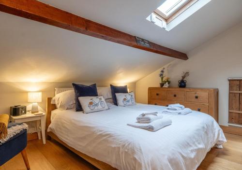 a bedroom with a large white bed with blue pillows at The Coach House - Cosy Retreat in Warwickshire! in Shottery
