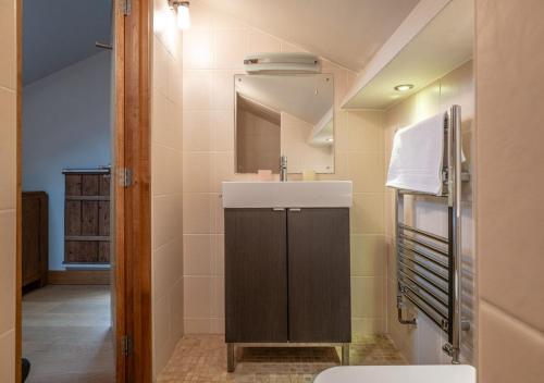 a bathroom with a sink and a mirror at The Coach House - Cosy Retreat in Warwickshire! in Shottery